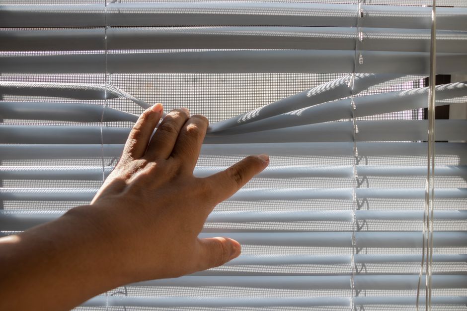 Worker installing window blinds